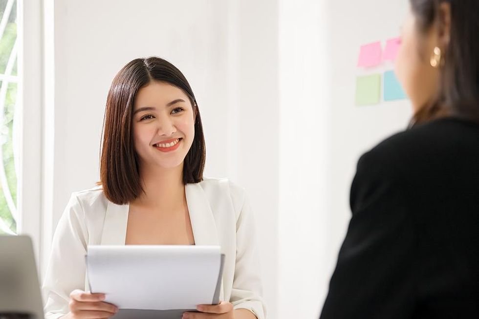 Hiring manager looks at a job seeker's resume at a job fair