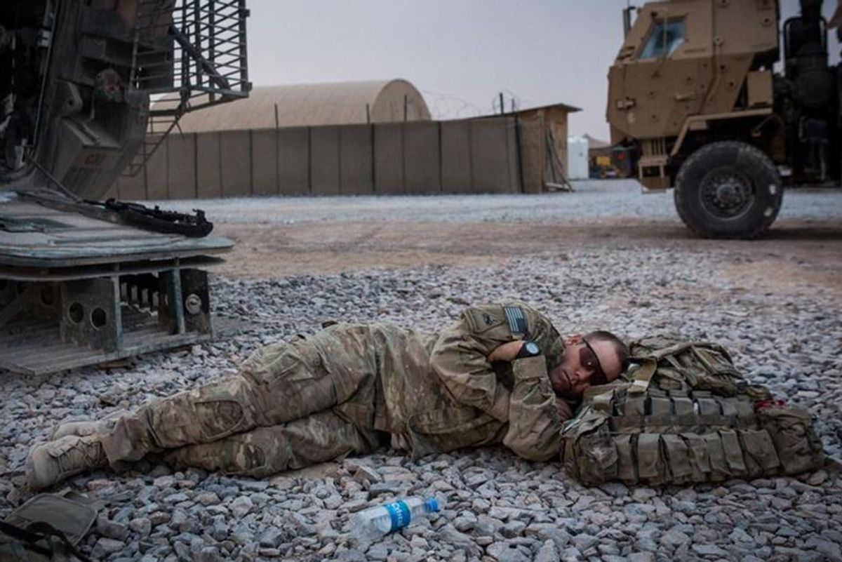 soldier in military uniform napping on the ground