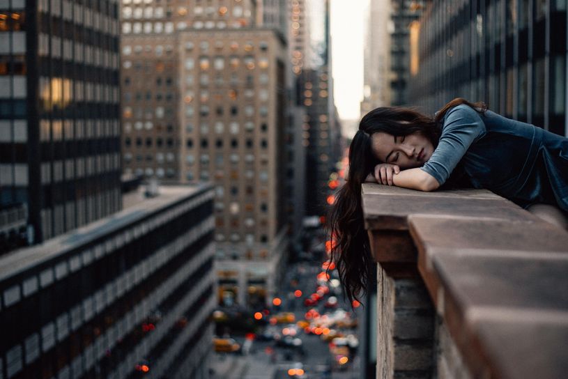 woman leaning on ledge with eyes closed