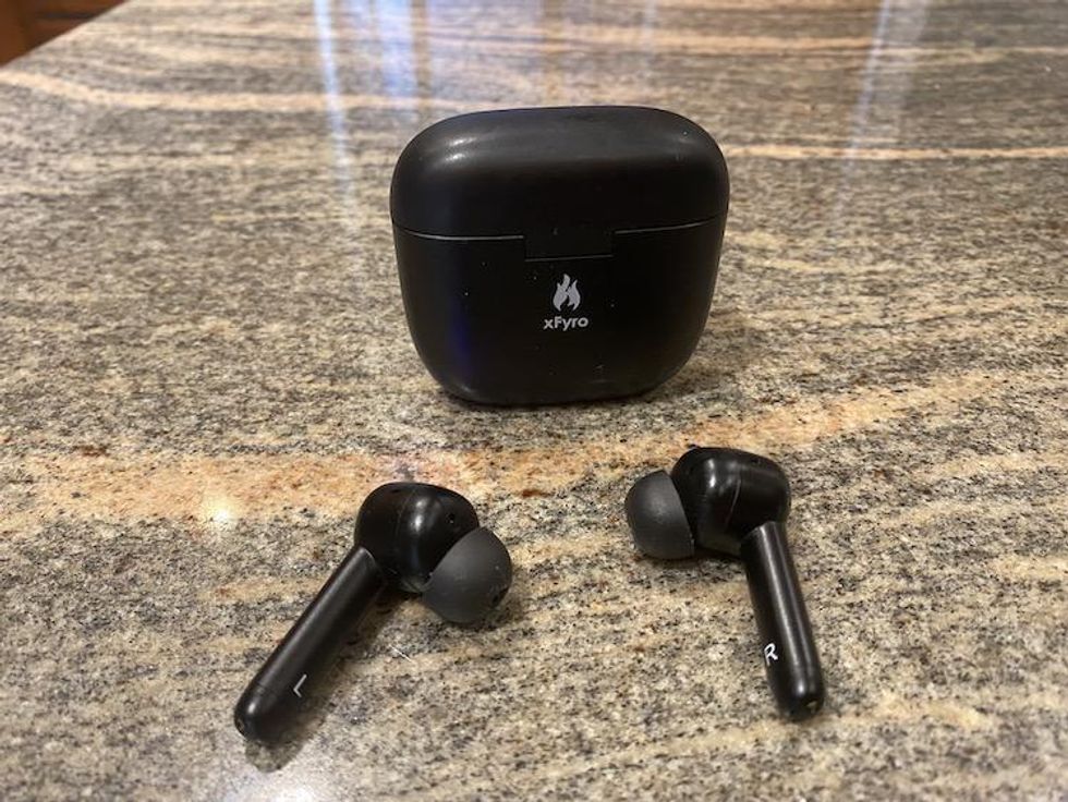 xFyro ANC Pro Wireless Earbuds on a countertop with wireless charging case