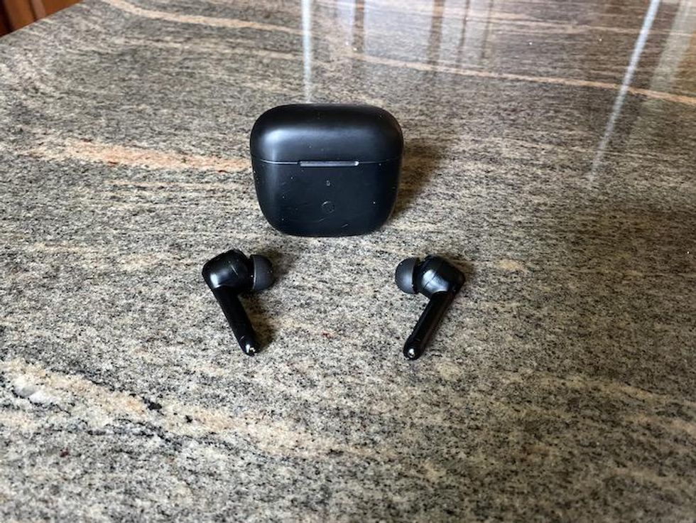 xFryo ANC Pro Wireless earbuds on a counter with wireless charging case.