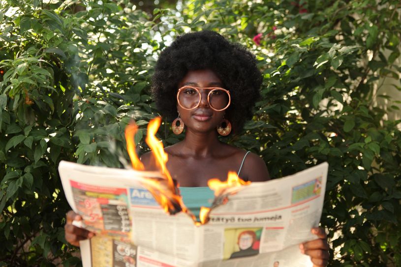 woman reading burning newspaper