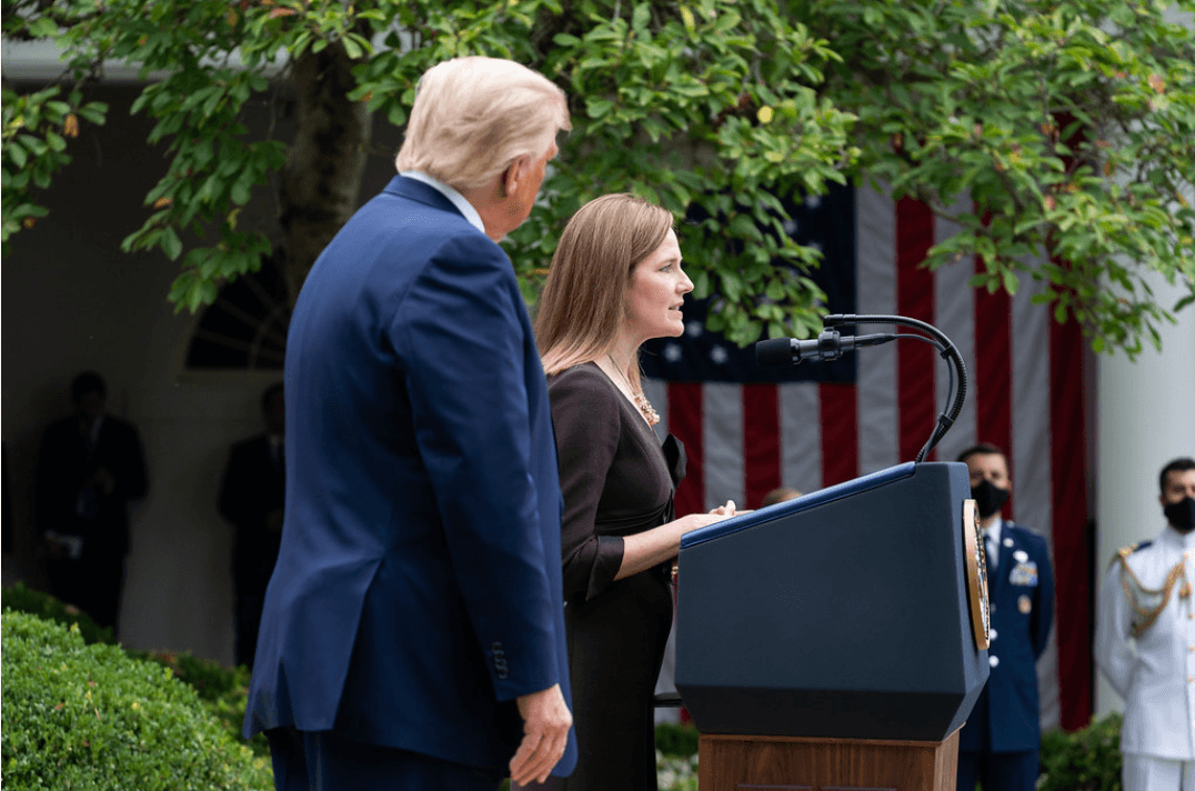 Justice Amy Coney Barrett speaks next to former President Trump, left. 