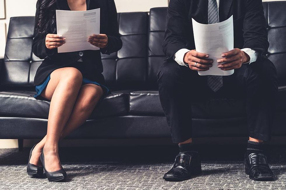 Job candidates hold their resumes before an interview