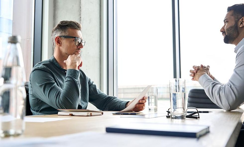 Hiring manager holds a job candidate's resume during an interview