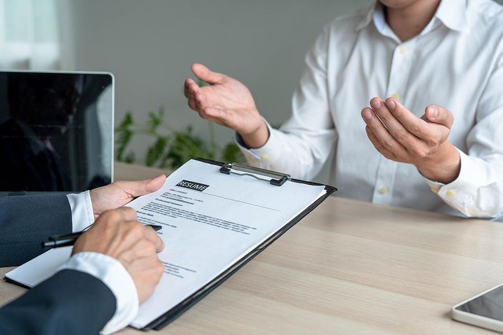 Hiring manager reads a job candidate's resume during an interview