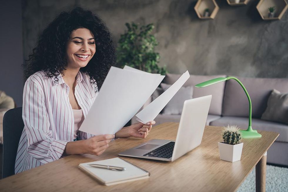 Woman smiles as she reads her resume and cover letter