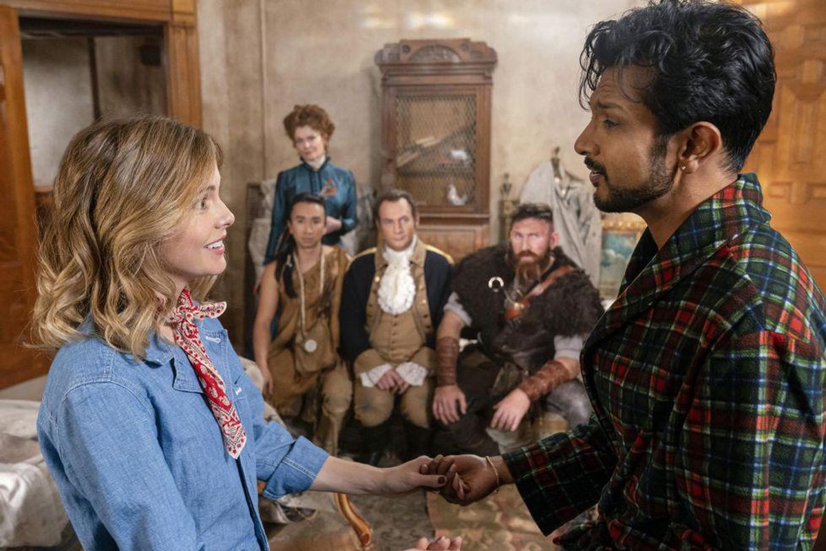 Rose McIver and Utkarsh Ambudkar look into each other's eyes as the resident ghosts look on.