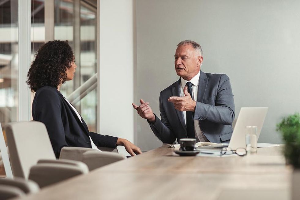 Woman listens to her boss during a performance review