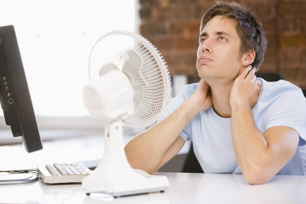 Man miserable in front of fan