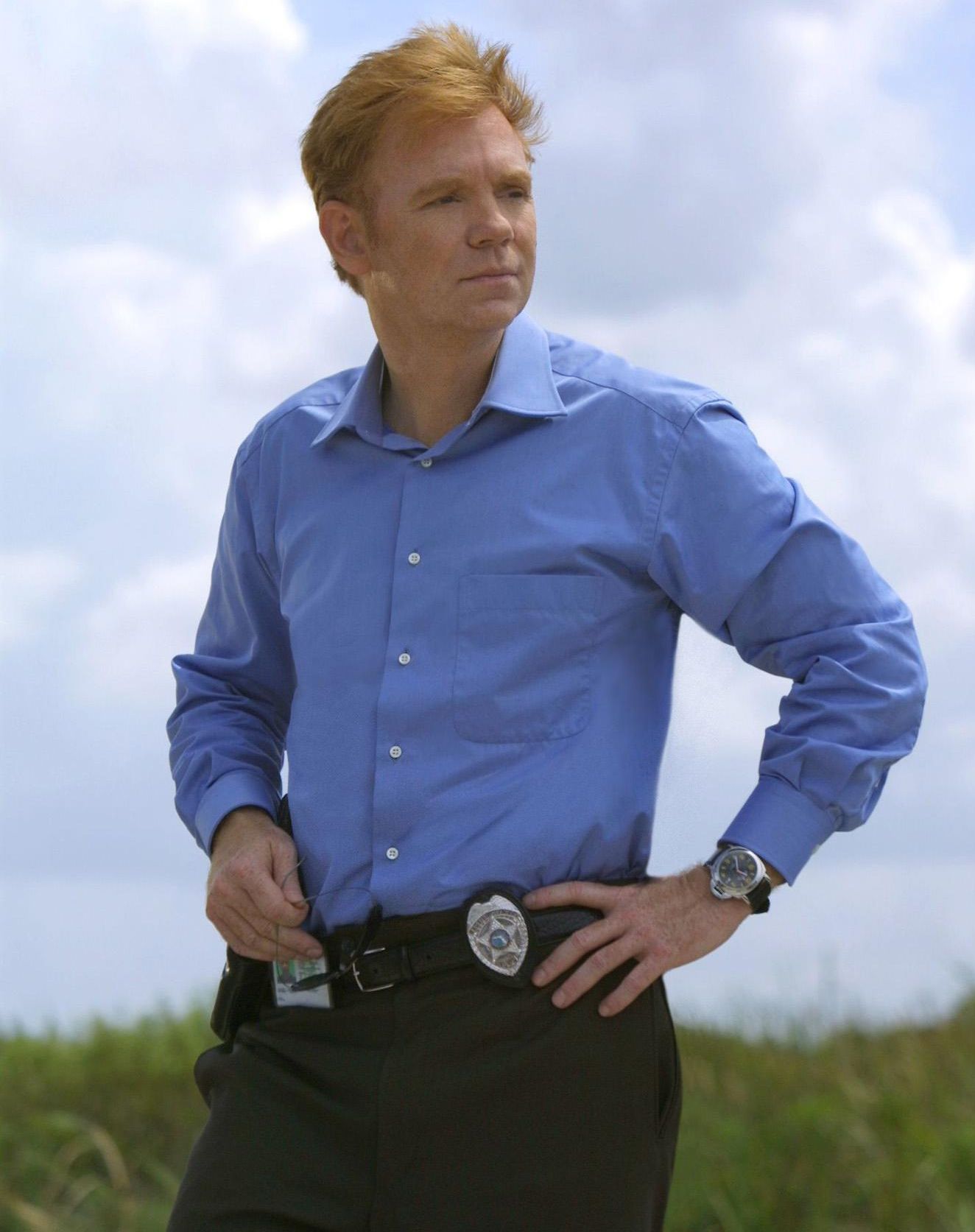 \u200bDavid Caruso as Horatio Caine standing in a field with his badge clipped to his belt