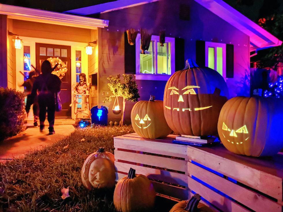Trick or treaters going to a front door on Halloween night.