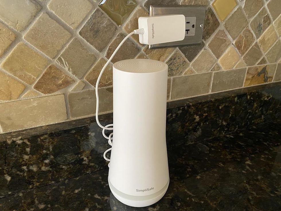 SimpliSafe Base Station plugged in on a countertop in a kitchen.