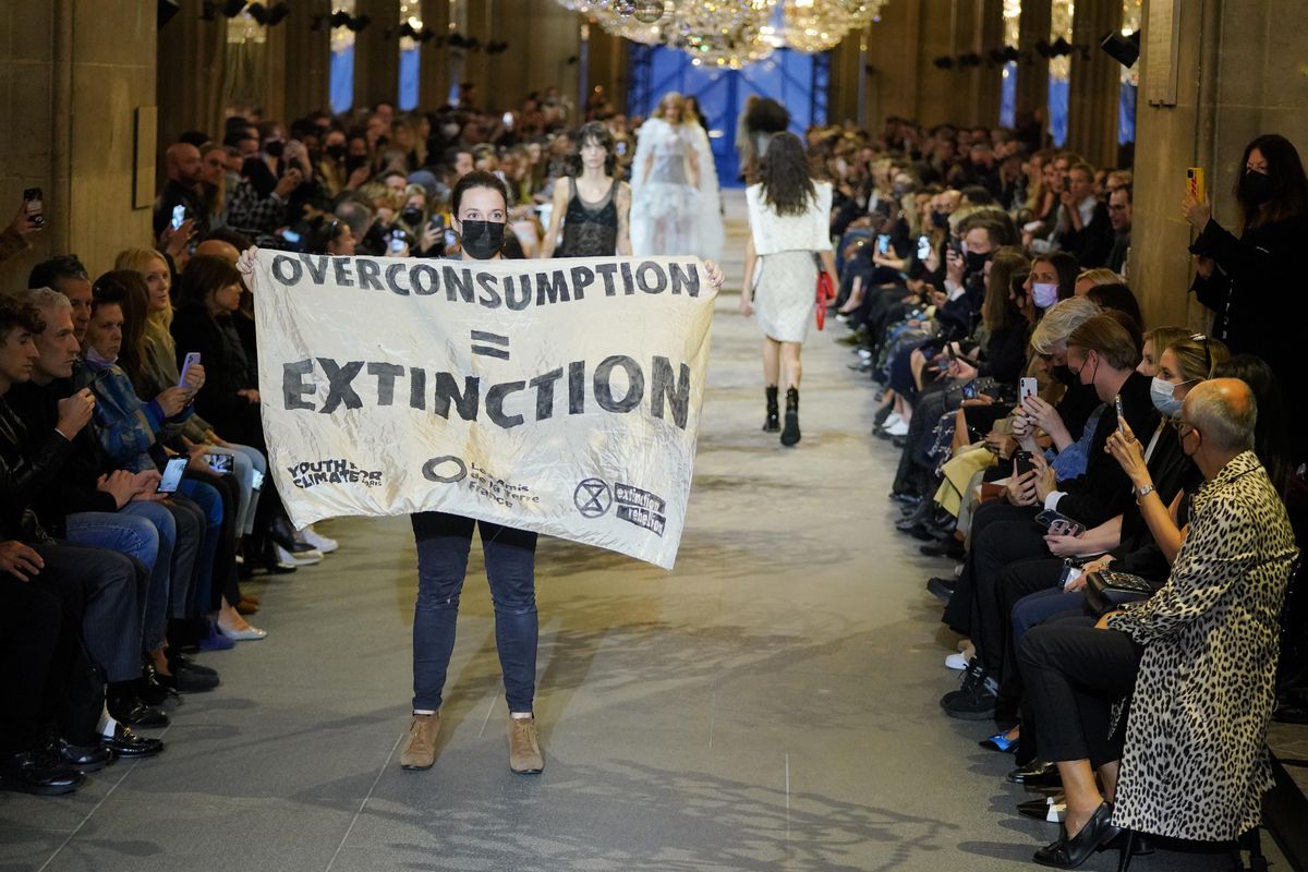 Protestor on Louis Vuitton SS22 Runway Show