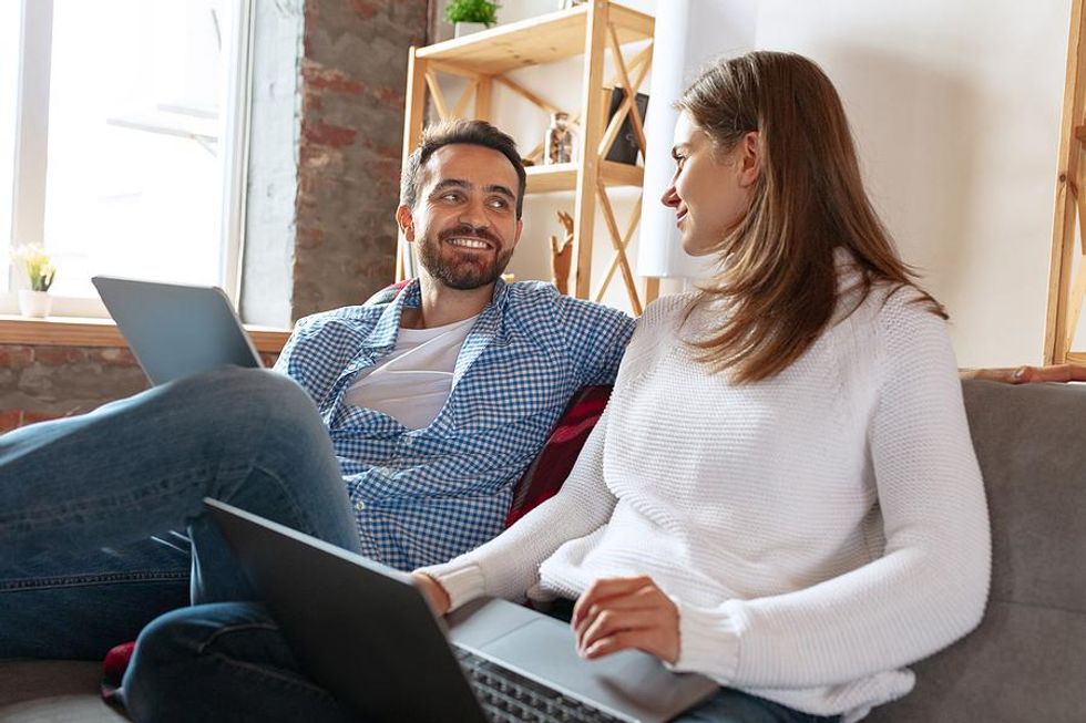 A couple sits together as they update their LinkedIn profiles