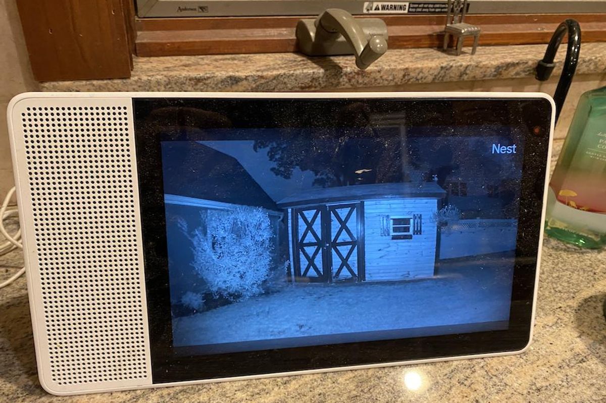 A google assistant smart display showing live video from Google Nest Cam at night time.