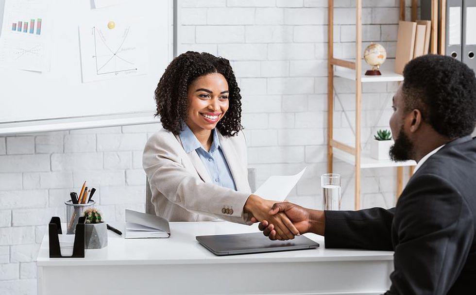 Hiring manager shakes hands with a job candidate