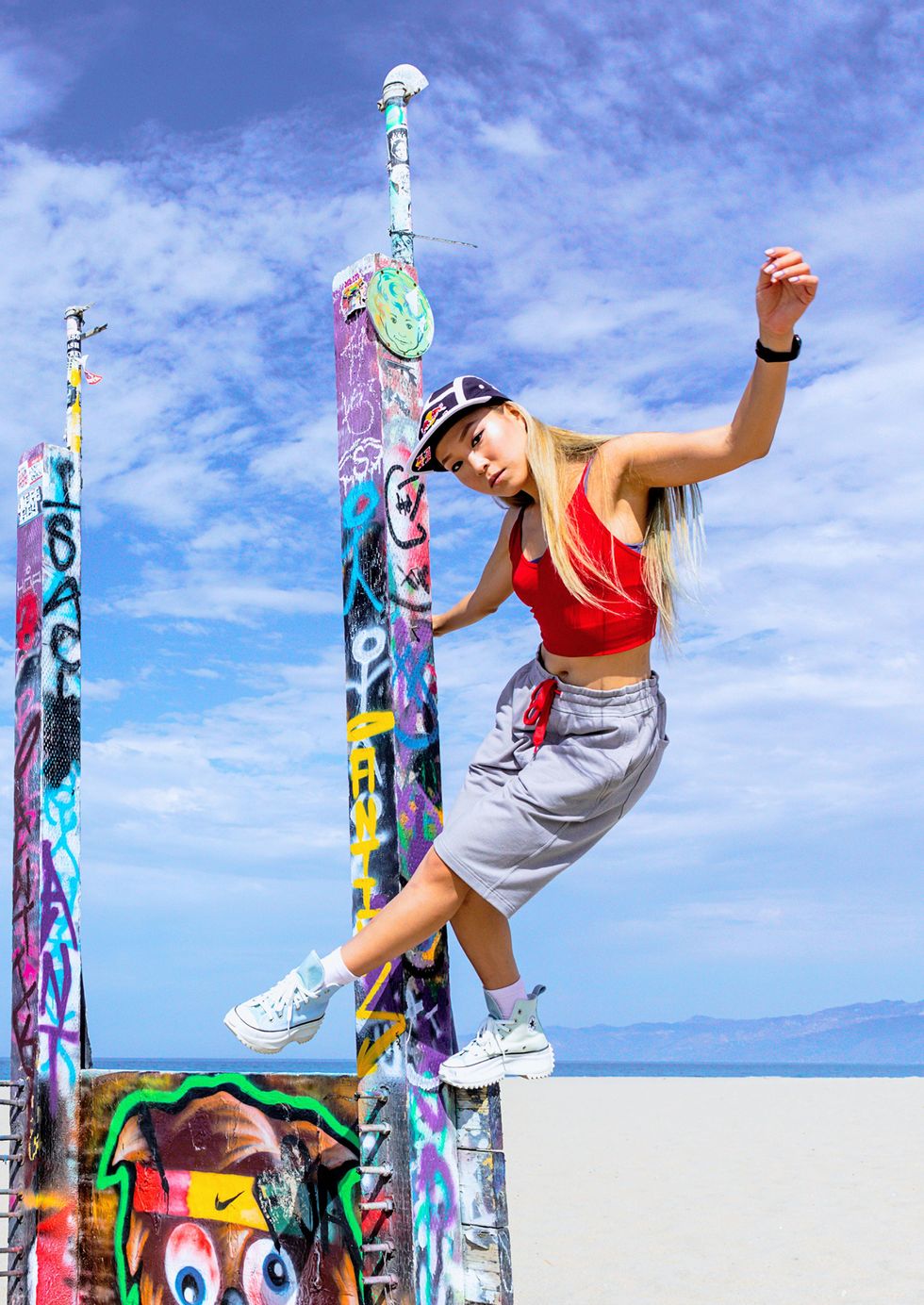 Lee leans away from a graffitteed pole