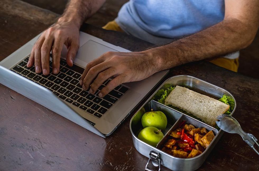 Man eating a healthy lunch while he works