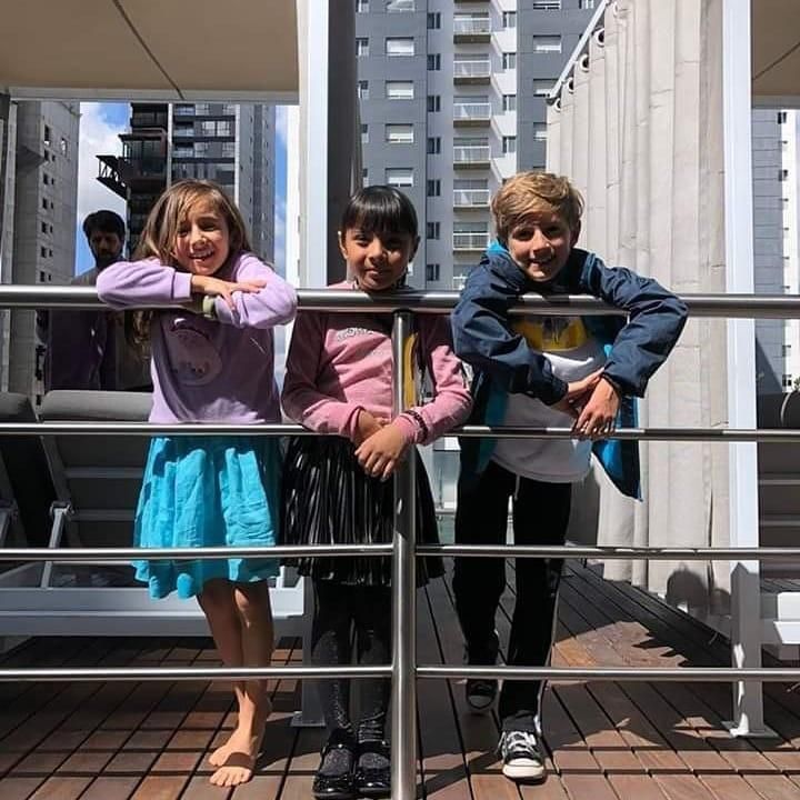 Ahara posing with two other kids in front of railing