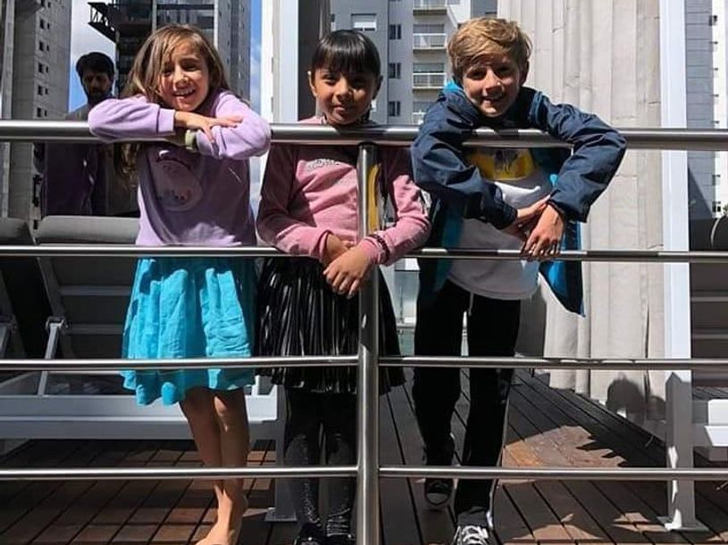 Ahara posing with two other kids in front of railing