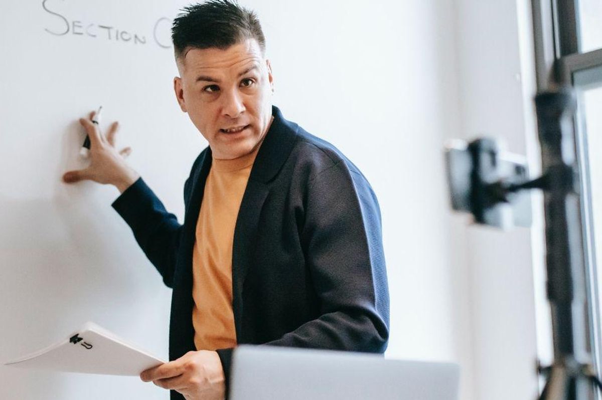 teacher pointing to white board