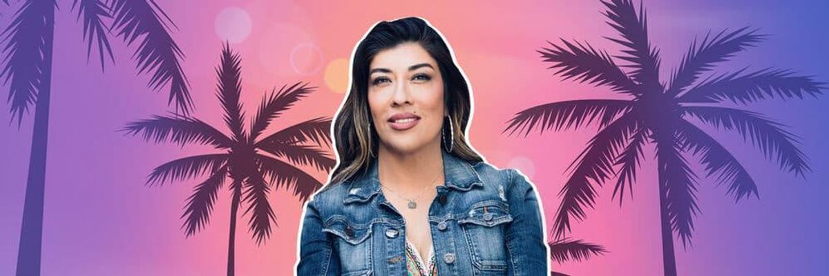 Photo of Lucy Flores smiling in front of palm trees.