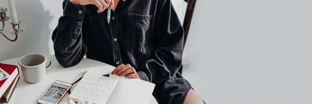 person at table writing a letter