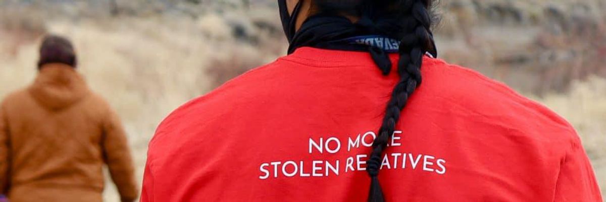 Back of a red shirt that says "No more stolen relatives".
