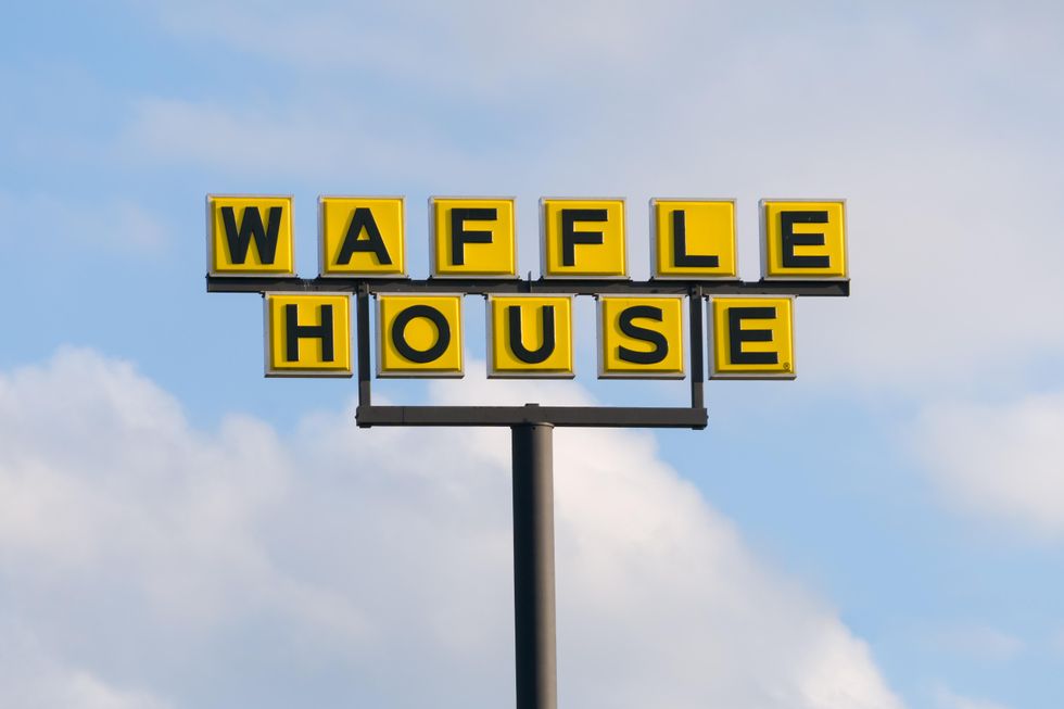 A Waffle House sign against a blue sky.