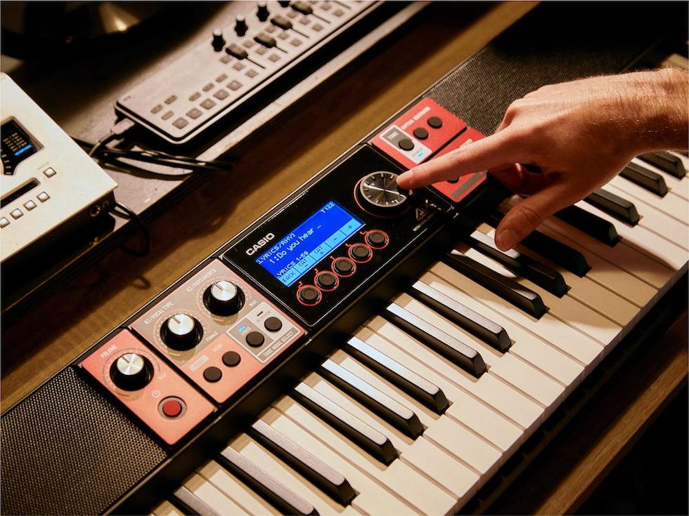 A musician using the controls on Casio Casiotone CT S1000V keyboard to adjust the sounds.