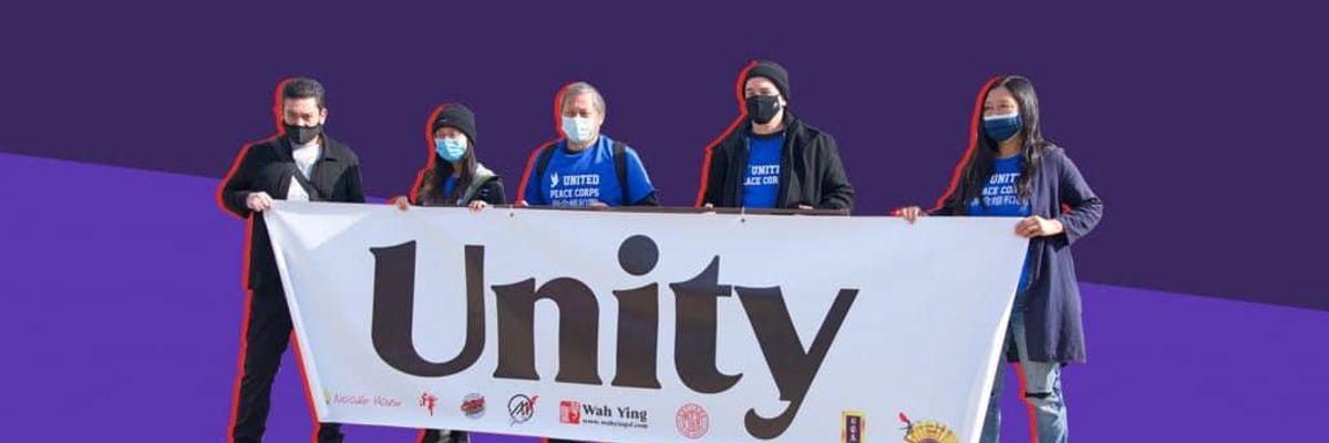 Five people holding a banner that reads "Unity".