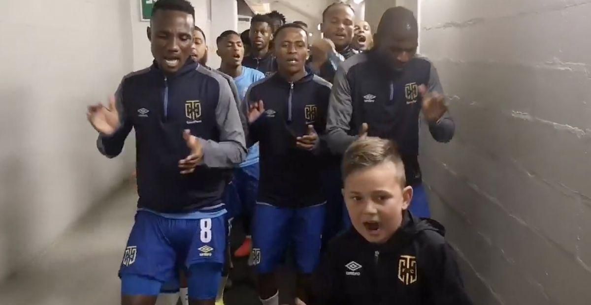 Young soccer fan leads team down the tunnel with motivating chant