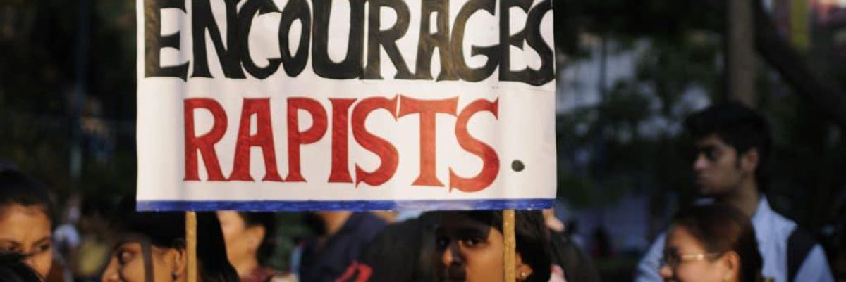 protest sign that reads, "silence encourages rapists"