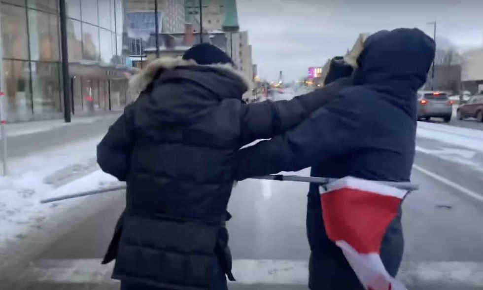 Dad confronts violent thug for stealing his 13-year-old daughter's Canadian flag amid Ottawa protests. Culprit ends up whimpering as cops handcuff him.