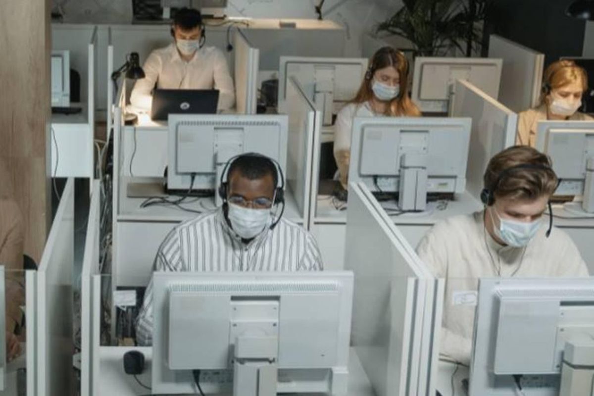 people in masks working at computers