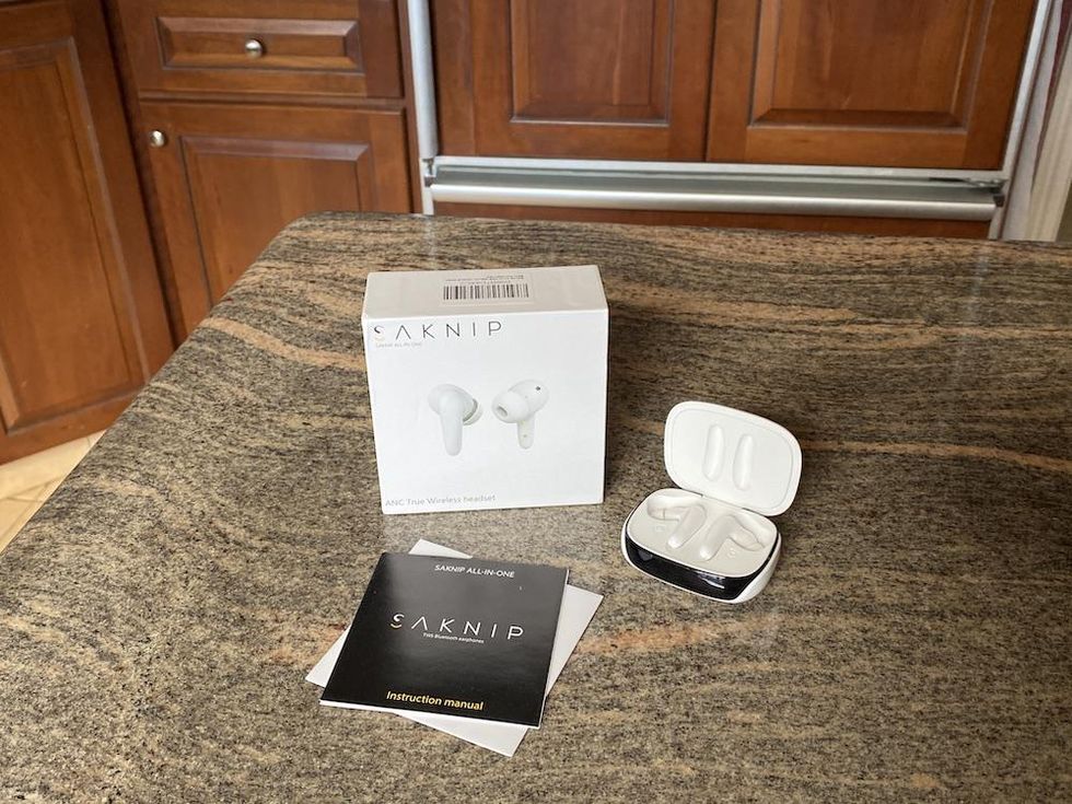 photo of Saknip earbuds unboxed on a countertop.