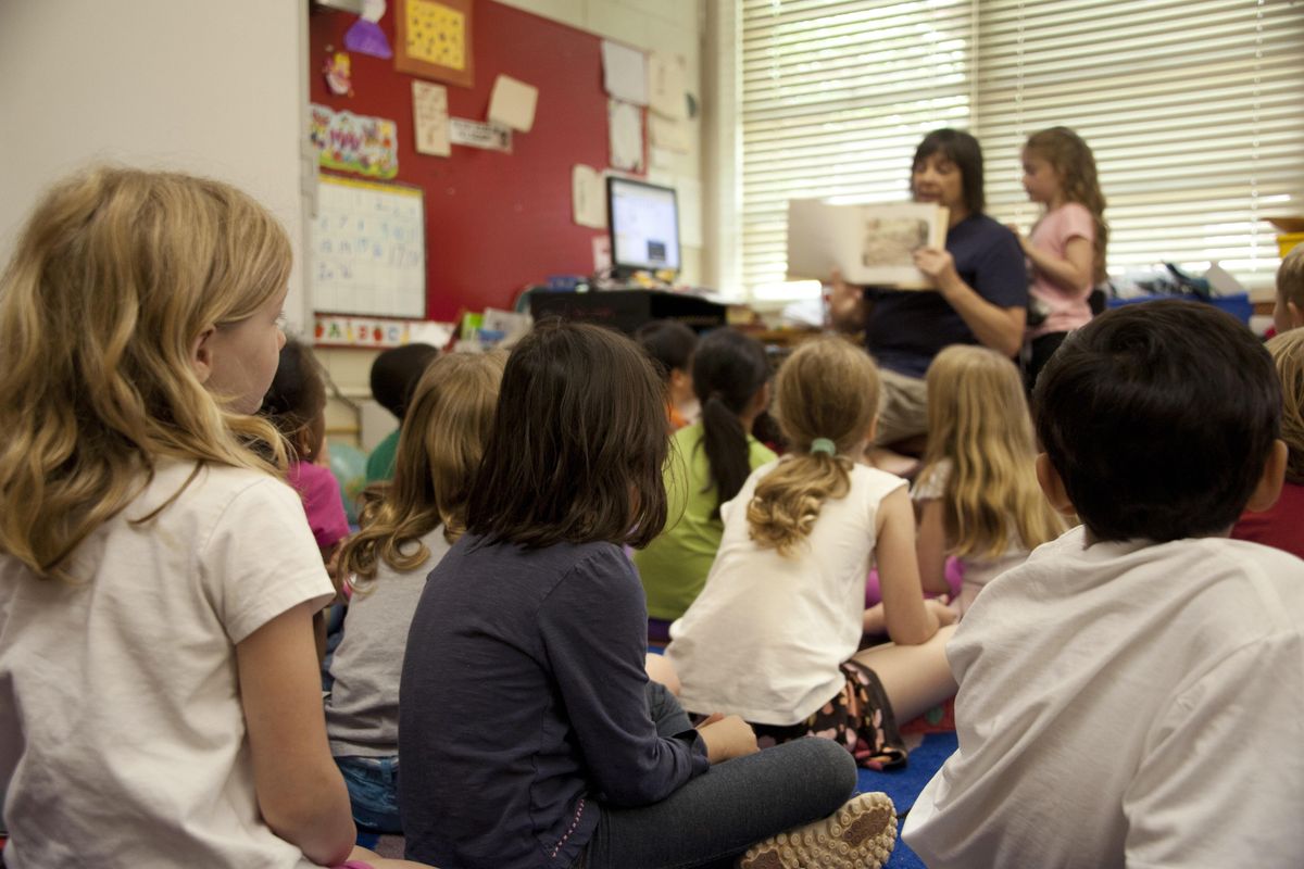 teacher reads to young students