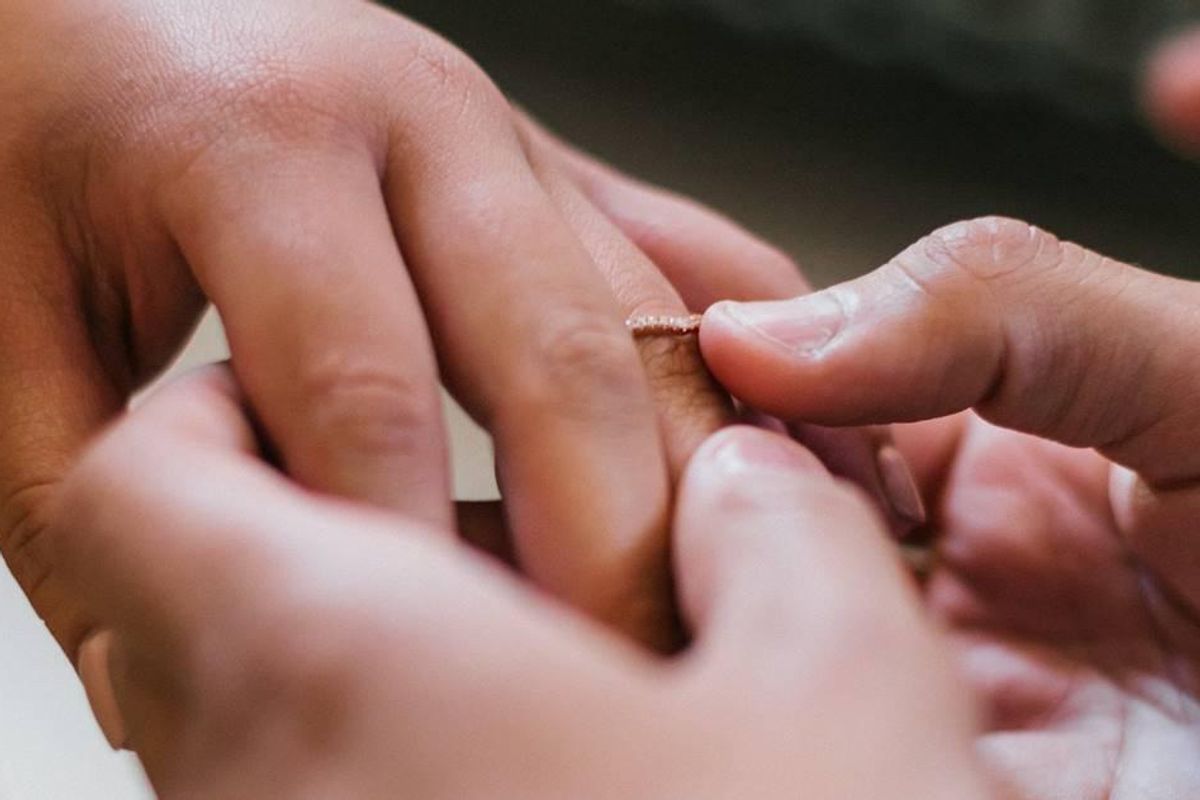 A couple exchanges wedding rings.