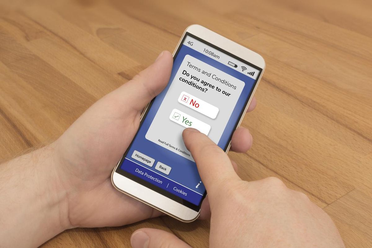 Photo of a smartphone and a user agreeing to terms and conditions