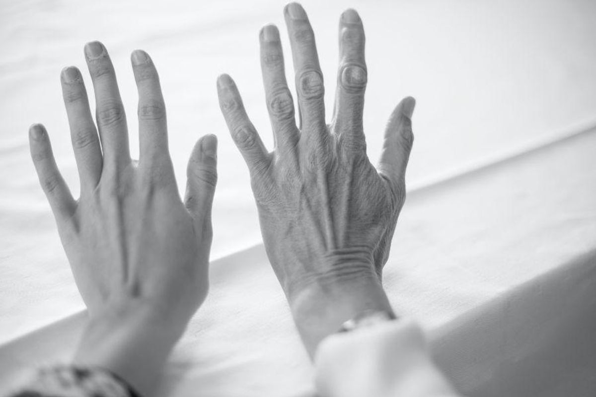 young hand beside an older hand in black and white