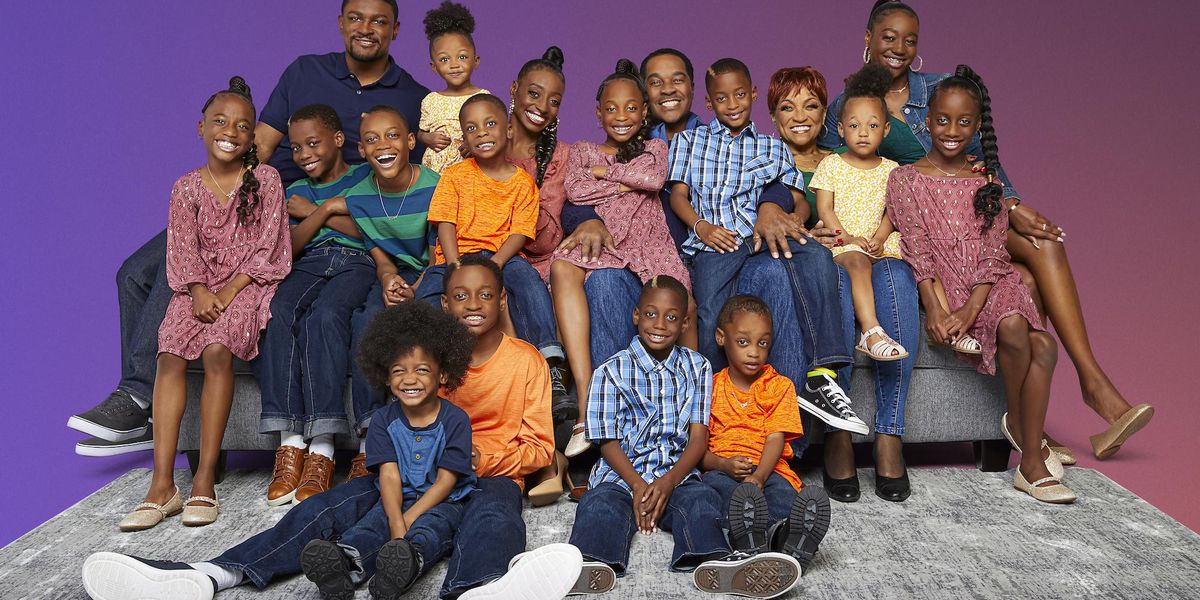 Black mother and father and their 14 children, sets of twins and triplets wearing bright colors