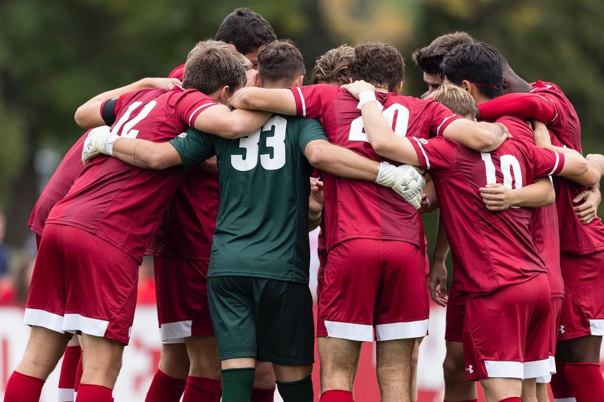 Men in red and white soccer uniforms in a huddle