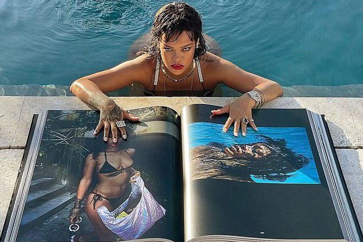 Rihanna posing with her book by the pool