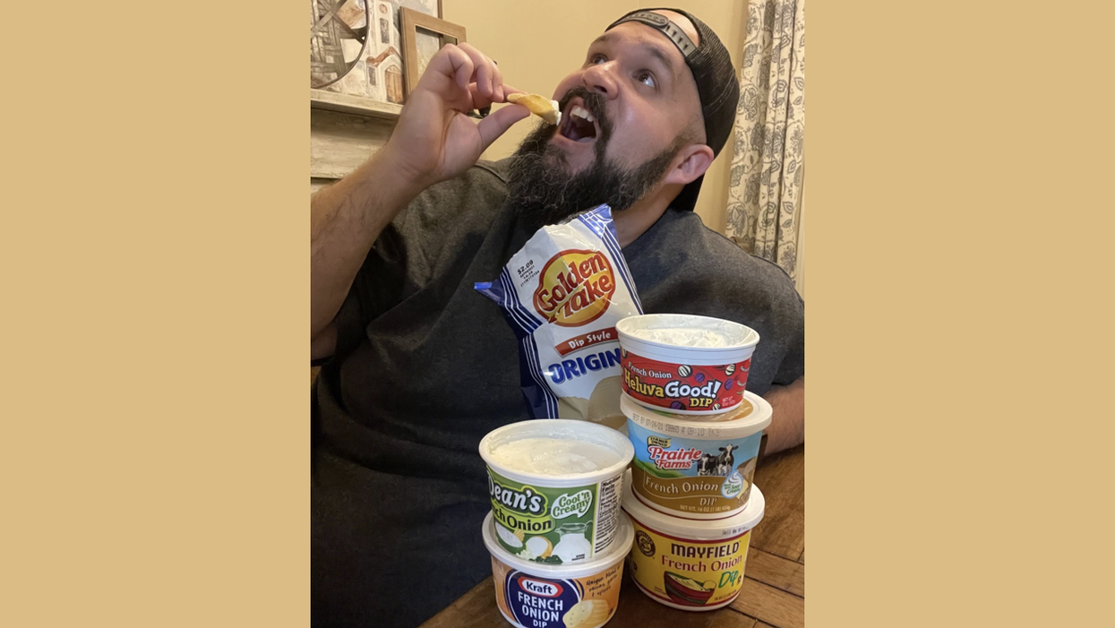 Matt holds chip with dip on it to his mouth as cartons of Dean's, Kraft, Prairie Farms and Heluva Good! dip sit in front of him.