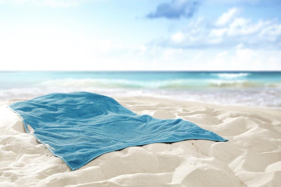 Crumpled blue towel on sand