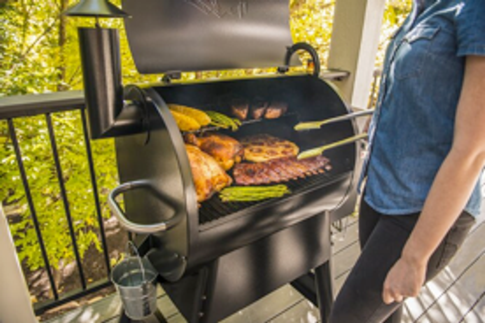 a picture of a man grilling on a Traeger Grill pro series 575