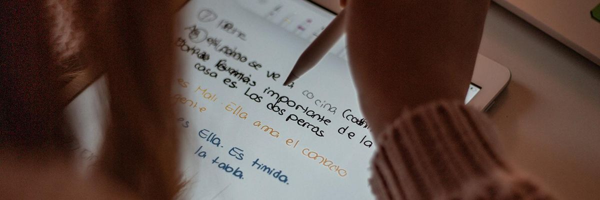 Woman writing sentences in Spanish on an ipad