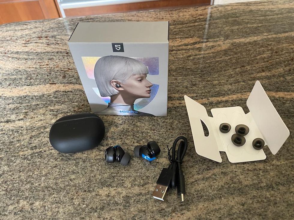 a photo of Soundpeats Mini Pro earbuds unboxed on a countertop