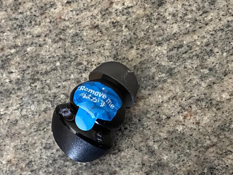 a photo of Soundpeats earbud with protective tape over the earbud